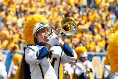 trombone player playing in front of football crowd